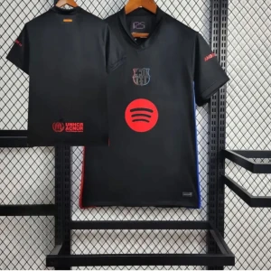 Svart FC Barcelona fotbollströja med Spotify-logga - Snygg svart FC Barcelona fotbollströja med klubbmärke och röd Spotify-logga på bröstet. UNHCR-tryck i rött på ryggen. Kortärmad modell med diskreta blå och röda detaljer i sidorna. Perfekt för dig som vill sticka ut på planen.