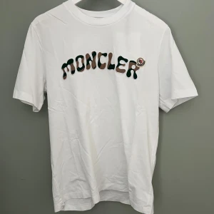 Vit t-shirt från Moncler med broderad logga - Fick den i present gillar inte den inte min stil, har för mycket kläder redan och vill rensa lite. Den är 100% äkta, helt oanvänd, helt ny.