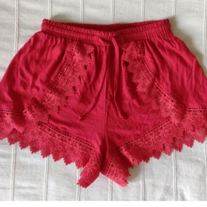 Röda shorts med spetsdetaljer - röda spetsshorts -  Röda shorts med spets - storlek 36. Bara använda någon enstaka gång och i fint skick.