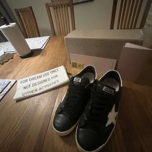 Svarta sneakers med vit stjärna - Säljer ett par svarta golden goose för att de har blivit för små.De är bra skick och inga defekter 