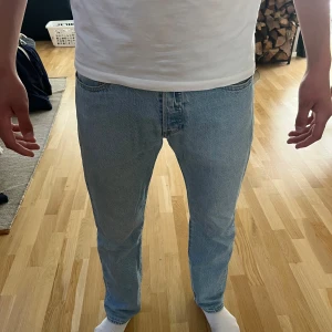 Levis 501 ljusblå jeans - straight fit - Säljer ett par klassiska Levis 501 jeans i ljusblå denim. Straight fit med normal midja och knappgylf. Ikonisk Levis-lapp bak i midjan och röda Levis-tag på bakfickan. Perfekta för en avslappnad stil. Passar till mycket och är perfekta på vår/sommaren. Mycket bra skick. Nypris: 1200kr. Mitt pris: 500kr. Sparsamt använda. Hör av er vid frågor eller funderingar! 🤩