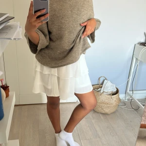 Vit volangkjol  - Säljer en söt vit kortkjol med dubbla volanger. Kjolen är perfekt för varmare dagar. Enkel att matcha med olika toppar!