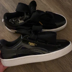 Svarta Puma sneakers  - Säljer ett par glansiga svarta puma sneakers med  breda svarta snören. Tyvärr för små för mig därav helt nya! ❣️
