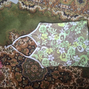 Blommig linnetopp med gröna och vita toner - Säljer en somrig linnetopp med blommigt mönster i grönt, vitt och beige. Toppen har smala axelband och är ärmlös, perfekt för varma dagar. Fräsch och trendig design som sticker ut.