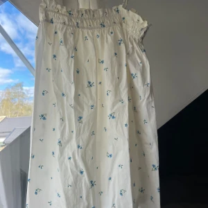 Sommarklänning - Säljer en vit klänning med blå blommor från H&M i storlek M. Säljer för 100kr