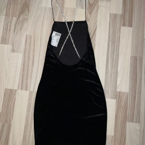 Svart minidress - Strl Xs. Svart figursydd klänning i sammetsmaterial, remmar med ” diamanter ” som blir crisscross där bak. Helt ny och jättesexig.        Ej genomskinlig! 📏 80cm
