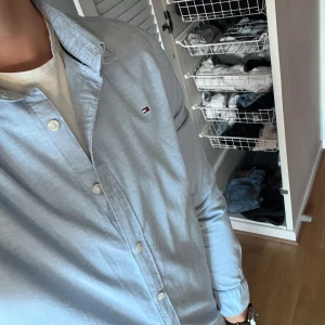 Tommy Hilfiger skjorta. - Standard ljusblå Tommy Hilfiger skjorta i storleken 176 cm. I princip oanvänd. Pris kan diskuteras.