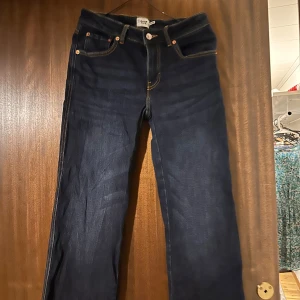 Mörkblå raka jeans - Snygga mörkblå jeans med raka ben och klassiska kontrastsömmar. Byxorna har fem fickor och stängs med knapp och dragkedja. även fickor ibak med knapp 