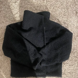 Kappa från Gina - Mysig marinblå teddyjacka med stor krage och boxig passform. Jackan har en fluffig yta som ger en cool och trendig look, perfekt för kyliga dagar. Enkel att matcha med olika outfits och riktigt skön att bära. Från gina i storlek M