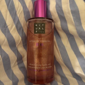 Rituals The Ritual of Yozakura duo - Säljer två produkter från Rituals The Ritual of Yozakura: en shimmering body oil med svart ris och yoshino cherry i en glittrig brunrosa ton samt ett body serum med niacinamid och svart ris-extrakt i en frostad flaska💕