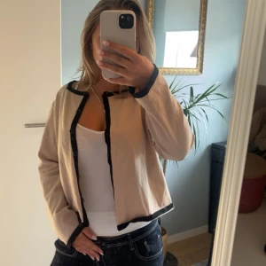 Beige kofta med svarta detaljer!🥹💞 - Säljer en beige kofta med svarta kanter och knappar framtill🩷🩷Tycker den är så söt till hösten, perfekt att ha över ett linne🙏🏼