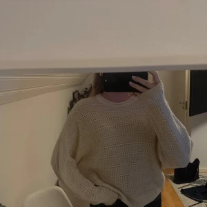 Beige stickad oversized tröja - Supermysig beige stickad tröja med breda ärmar och avslappnad oversized passform. Tröjan har ett snyggt hålmönster och rund halsringning, perfekt att slänga på sig när det är kyligt ute.