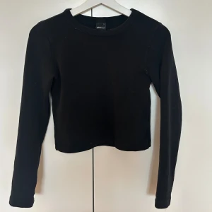 Svart långärmad tröja Gina Tricot - En basic svart långärmad tröja från Gina Tricot i storlek S. Tröjan har rund halsringning och en rak, något croppad passform. 