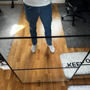 Blå regular fit jeans från H&M - Säljer ett par klassiska blå jeans från H&M i regular fit. De har en rak passform och är tillverkade i mjukt denimtyg med snygga kontrastsömmar. Perfekta för dig som gillar en enkel och stilren look.