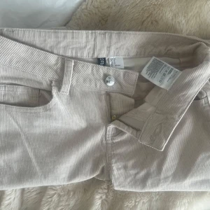 Beiga manchesterbyxor från hm  - Snygga beiga manchesterbyxor från hm. Superlågmidjade och bootcut. Säljer pga att de är för små för mig💕några små fläckar som knappt syns