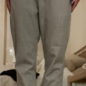 Grå kostymbyxor från Coster Copenhagen - Snygga grå kostymbyxor från Coster Copenhagen i rak modell. Byxorna är tillverkade i en mix av polyester och viskos, vilket ger en mjuk och lätt känsla. Perfekta att styla med en enkel t-shirt eller skjorta för en clean look.