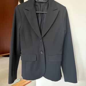 Svart kavaj från Twilfit - Svart kavaj från Twilfit i strl 38, men sitter perfekt oversized på mig som bär 34. Endast använd fåtal gånger!