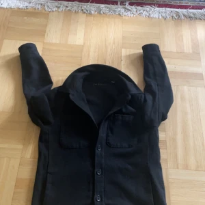 Svart overshirt från Donce de la sense  - Svart overshirt från Donce de la sense. Köpt direkt från butiken, bra skick och snygg inför höst och vintern. Passar xs -s 