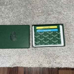 Grön G korthållare - Säljer en snygg grön korthållare från G med deras ikoniska mönster. Perfekt för att hålla koll på dina kort och enkel att ha i fickan. Kommer i originalask. Stilren och trendig accessoar för dig som gillar lyxiga detaljer.