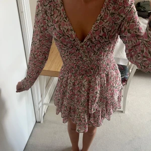 Klänning från ZARA - Säljer denna klännig från Zara, med guldiga knappar och åtsittande midja. Superfint blommigt mönster. Använt ett fåtal gånger. Jag är 170. Är i storlek XS men skulle säga att den passar för dom som har S också!