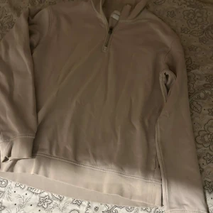 Beige half zip tröja Jack & Jones - Snygg beige långärmad tröja från Jack & Jones med half zip-dragkedja och hög krage. Mjuk insida och ribbade muddar vid ärmslut och nederkant. Perfekt för lager-på-lager och chill dagar.