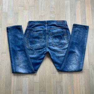 Dondup George - Snygga blå jeans från Dondup med väldigt feta slitningar på både fram och baksida. Jeansen är i bra skick och perfekta för en avslappnad och trendig look.