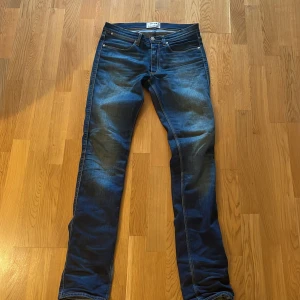 Blå jeans från Acne Studios - Snygga blå jeans från Acne Studios med klassisk femficksdesign och diskreta slitningar. Jeansen har raka ben och normal passform, perfekt för en clean och stilren look. Materialet är robust denim som känns både mjukt och hållbart.