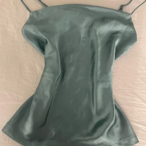 Grön/blå  satinlinne från Anna Field - Snygg grön satinlinne från Anna Field med tunna justerbara axelband. Perfekt för en elegant look. Linnet har en mjuk och glansig yta som ger en lyxig känsla. Storlek 38