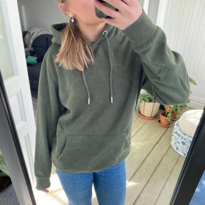 Grön hoodie från 157 - Säljer en grön hoodie från 157 i storlek S. Den har en klassisk design med en stor ficka framtill och justerbar huva med snören. Perfekt för en avslappnad stil. 🧥