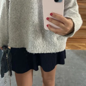 Mörkblå stickad kjol från Zara - Säljer en mörkblå stickad kjol från Zara. Kjolen är ribbad vilket ger en stilren look. Perfekt för att matcha med en stickad tröja eller blus. Så snyggt nu under vår och sommar