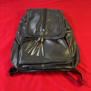 Svart ryggsäck med fransdetaljer - Helt ny .Skolväska för kvinnor Klassisk svart vattentät reseaxelväska Multifunktionsryggsäck för kvinnor .Snygg svart ryggsäck i syntetmaterial med flätad dragkedja och fransdetaljer. Perfekt för att bära dina saker med stil. Justerbara axelremmar och flera fack för enkel organisering.