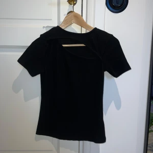 Ribbad topp med cut-out  - Svart ribbad topp från Camaieu. Köpt i Paris för något år sedan men använd ett fåtal gånger. Väldigt bra skick. Passar xs-s.  