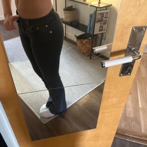 Svarta jeansbyxor - Snygga svarta jeansbyxor med låg midja och klassisk femficksdesign. Byxorna har en dragkedja och knappar framtill. Perfekta för en avslappnad stil.