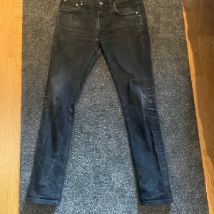 Svarta jeans från Nudie Jeans - Snygga svarta jeans från Nudie Jeans med en klassisk femficksdesign. De har en normal passform och är tillverkade i högkvalitativt denim. Perfekta för en stilren look.