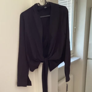 Svart blus med knytskärp - Svart blus med knytskärp från shein. Passar till vardags eller till festligare tillfällen.