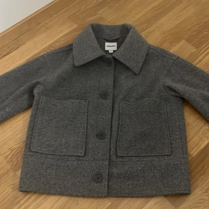 Grå kappa från Kappahl - Säljer en stilren grå kappa från Kappahl i storlek XS. Jackan har stora framfickor och knäpps med knappar framtill. Perfekt för kyligare dagar med sin klassiska design och bekväma passform. Nypris 899, säljer för 300💓