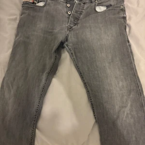 Jeans diesel industry  - Snygga grå jeans från Diesel med knappgylf och klassisk femficksdesign. Perfekta för en avslappnad stil med en touch av edge. Passar bra till både sneakers och boots.