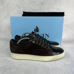 Lanvin DBB1 cap toe sneaker - – Condition: 8/10  - Size: 41/UK7  – What is included: Dustbag  – Retail price: 6000 + SEK  Please note that Lanvins fit big and our recommendation is to go one size down