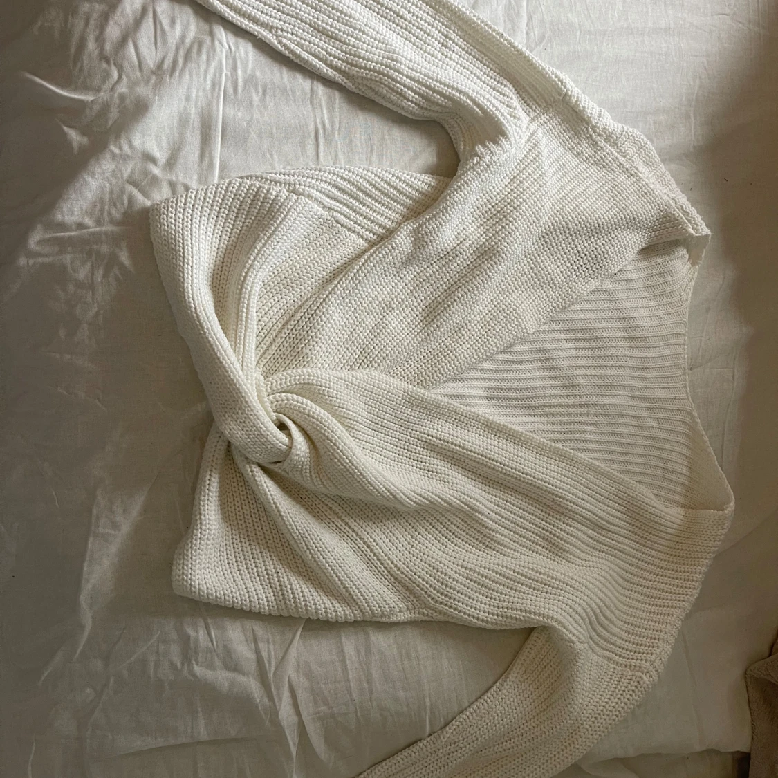 Vit stickad omlottkofta med knut