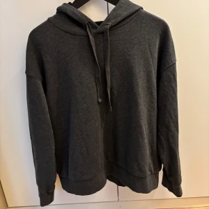 Mörkgrå hoodie med huva och snörning - Säljer en mörkgrå hoodie med huva och snörning. 