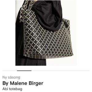 By Malene Birger svartvit shoppingväska - Säljer en snygg Abi totebag från By Malene Birger. Väskan är svartvit med grafiskt mönster och har detaljer i svart skinn. Rymlig insida med dragkedjefack och guldfärgade metalldetaljer. Perfekt för dig som vill ha en trendig och praktisk väska med ikonisk design. Top begagnad skick, väldigt ren inuti, lite använd, defekt på axelremmen. 