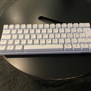 Tangentbord  - Bilderna visar ett vitt tangentbord av modellen NOS C450. Tangentbordet har nordisk layout med specialtecken och funktionstangenter. Perfekt för dig som vill ha en kompakt och stilren setup till datorn. Passar både gaming och studier.