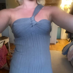 Grå ribbad oneshoulder klänning - Grå midilång klänning med ribbad struktur och oneshoulder-design. 