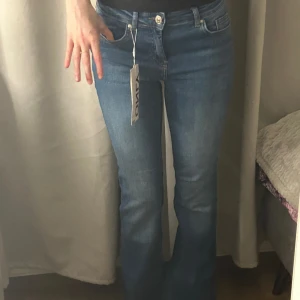 Blå flared jeans från ONLY - Snygga blå jeans från ONLY med flared ben och klassisk femficksdesign. Jeansen har normalhög midja och är tillverkade i mjuk bomullsdenim med lite stretch. Perfekta för dig som gillar en retroinspirerad look med utsvängda ben.