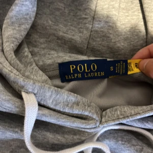 Grå hoodie från Polo Ralph Lauren - Säljer denna ralph lauren hoodie i storlek S. Den är oanvänd