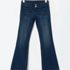 Mörkblå bootcut jeans med fickor - Snygga mörkblå jeans med bootcut passform och markerade sömmar längs benen även bekväma att ha på sig. 