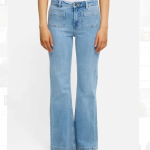 Ljusblå bootcut jeans med fickor - Snygga ljusblå jeans med bootcut-modell och två stora framfickor. Jeansen har hög midja och klassisk jeanslook med bälteshällor och dragkedja. Perfekta för en trendig och avslappnad stil.
