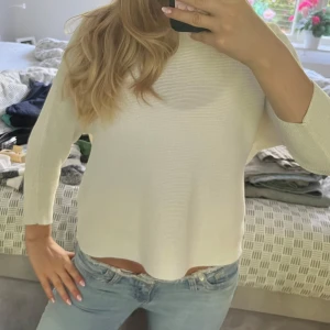Vit stickad tröja med trekvartsärm - En stilren vit stickad tröja med trekvartsärm och rund hals. Tröjan har en rak passform och är perfekt att matcha med jeans för en enkel och fräsch look. Materialet är mjukt och bekvämt, vilket gör den skön att bära hela dagen. Storlek S❤️