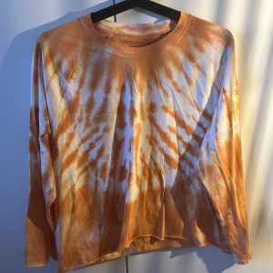 Orange tie-dye tröja - Långärmad orange tie-dye tröja. Luftig avslappnad passform i mjuk bomull,  avklippt där nere.