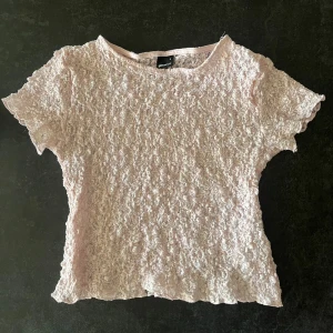 Ljusrosa spetsblus från Gina Tricot - Supersöt ljusrosa blus i spets från Gina Tricot. Kortärmad modell med rund hals och vågiga kanter. Perfekt för dig som gillar romantisk stil och vill ha något extra till outfiten.💕💕